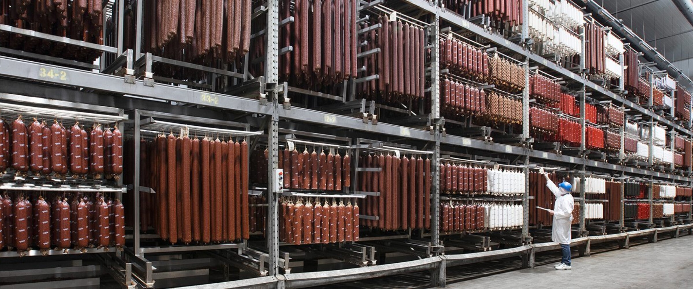 Piller's worker doing inventory of meat products in a temperature controlled warehouse.